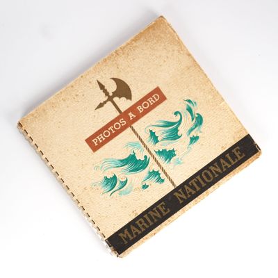 un vieux livre posé sur une table blanche, à côté d'un couteau