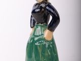 a figurine of a woman wearing a green skirt