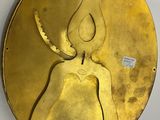 a gold plate with an image of a woman on it