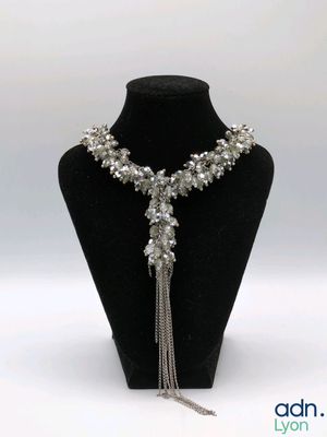 a close up of a necklace on a mannequin with a chain