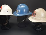 three different types of hard hats on display on a black background