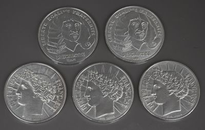 quatre pièces d'argent de tailles et de formes différentes sur un fond noir