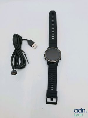 une montre connectée reliée à un câble USB