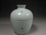 a white vase with a lid sitting on a table