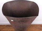 a large metal funnel that is sitting on a wooden floor
