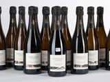 six bouteilles de vin sont alignées sur une table
