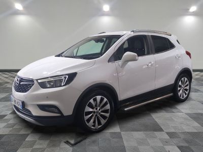 un SUV Buick blanc garé sur un sol à damier dans un garage