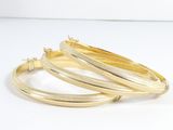 une paire de boucles d'oreilles pendantes dorées sur fond blanc
