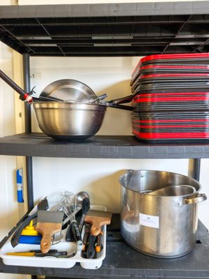 de nombreuses casseroles et poêles sur les étagères de la cuisine
