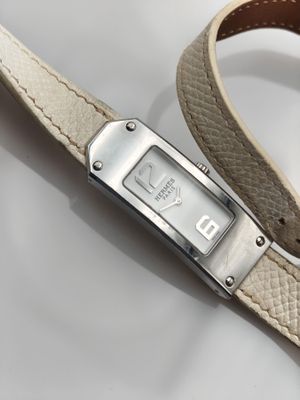 une image représentant une montre-bracelet avec un bracelet en cuir posée sur une surface blanche