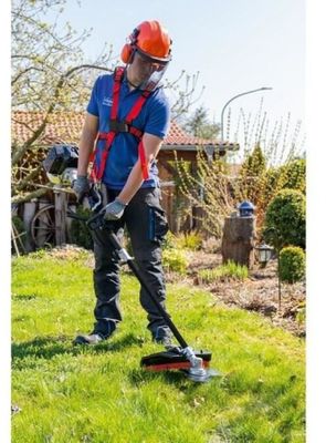 Cet homme utilise une débroussailleuse filaire pour tailler le gazon.