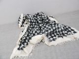 the black and white scarf is laying on top of the couch