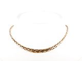 gros plan d'un collier en or sur une surface blanche