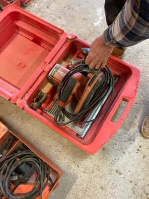 a man that is holding a tool in a red box