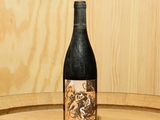 une bouteille de vin posée sur un tonneau en bois