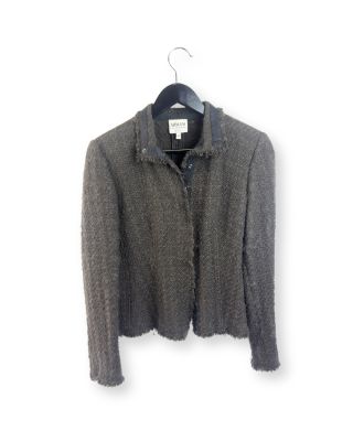 un cardigan gris suspendu à un cintre sur fond blanc