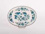 blue and white plate with flowers on it on a stand