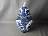 a blue and white vase with a lid sitting on a table