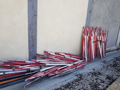 a pile of baseball bats leaning against a wall