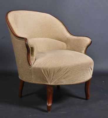 a beige upholstered chair with wooden legs and a curved back