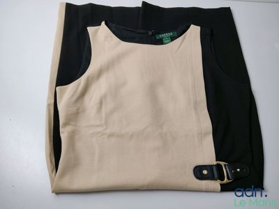 the top of a black and beige shirt with a belt
