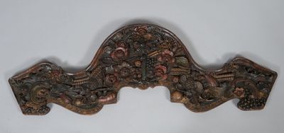 an ornately carved wooden door handle on a white wall