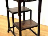 a wooden table with a shelf on it on a hard wood floor