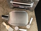 a toaster, a toaster, a spatula, and a knife on a rug