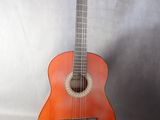 an orange guitar sitting on top of a white sheet
