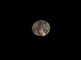 un hibou perché sur un rocher dans l'obscurité, avec la pleine lune en arrière-plan