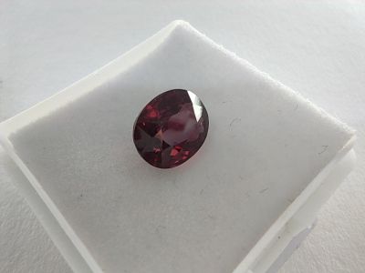 un gros plan d'un grenat rouge sur une surface blanche