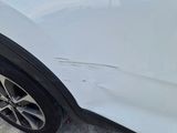 a close up of a white car with scratches on the side of it