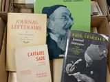 plusieurs livres dans une boîte en carton posée sur une pile de livres