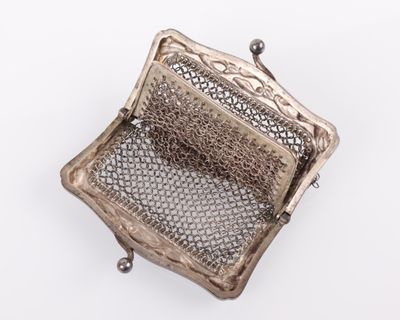 un sac à main ancien en argent muni d'une anse en filet, sur fond blanc