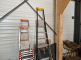 several ladders are stacked up against a wall in a garage
