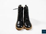 black leather boots with laces and rubber soles on a white background
