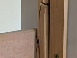 a hand that is holding a piece of wood near a door