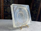 a small glass plate on a table with a gold stand