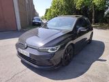 une Volkswagen Golf R-Line noire garée devant un immeuble