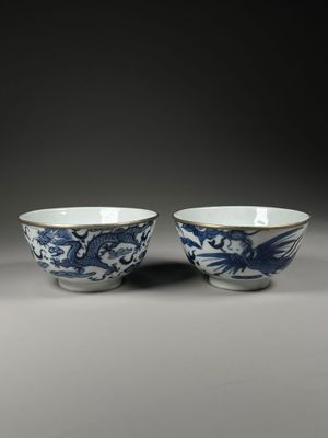 pair of blue and white bowls with dragon handles
