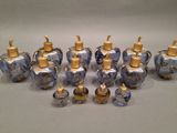 six blue glass bottles with gold caps are lined up on a gray surface