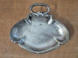 a silver plate with a handle on a wooden table