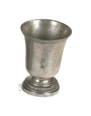 a silver cup sitting on a pedestal on a white surface