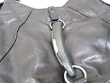 a black purse with a metal handle on a white surface