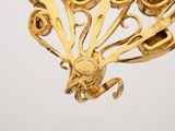 an image of a gold broochle with scissors and a pin