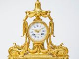a gold clock sitting on top of a table