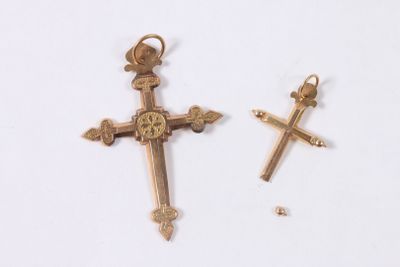 deux croix dorées côte à côte sur un fond blanc