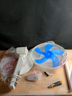 une table sur laquelle se trouvent un ventilateur et d'autres objets