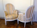 pair of white and yellow striped chairs in a room with wood flooring