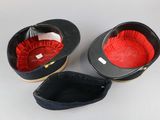 pair of black and red hats with red linings on them